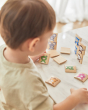 Close up of young boy stacking the pieces from the PlanToys wooden Waldorf animal guessing game