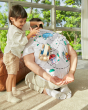 Young child pushing the PlanToys wooden sensory roller toy across a mans back