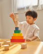 Young boy sat at a table stacking the PlanToys plastic-free wooden counting cubes