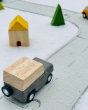 Close up of the PlanToys grey wagon on the PlanToys rubber road and rail toy set on a white background