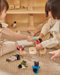 Close up of 2 girls playing with the PlanToys plastic-free wooden Victorian dollhouse furniture