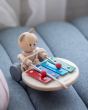 Close up of the PlanToys pull along xylophone bear toy on a grey sofa