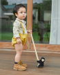Young boy stood on a wooden floor holding the PlanToys solid wooden climbing gorilla toy