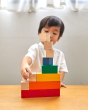 Young boy making a stack with the PlanToys wooden rainbow counting cubes