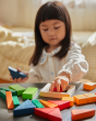 Close up of young child playing with the PlanToys Waldorf fraction blocks toy set