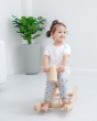 Toddler sat on the wooden foldable rocking horse by PlanToys. Front view.