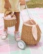 A child holding the Olli Ella Rattan Berry Basket with Lining – Gumdrop, and the Gumdrop Luggy