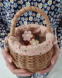 A child holding the Olli Ella Rattan Berry Basket with Lining – Gumdrop in their hand. The basket holds eggs and colourful flowers 