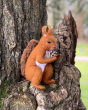 The Makerss Needle Felt Red Squirrell. A beautifully crafted red squirrel with a ginger and white felt body, brown bushy tail and black stick in eyes, stood in a tree and holding a pine cone
