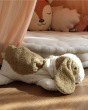 The Senger Cuddly Animal Organic Soft Toy - Small Dog lying on a wooden floor in a bedroom scene