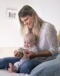 A parent and child sat together, playing with the Sophie la Girafe® - So'Pure Multi-textured Sensory Teether Ring