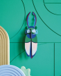 Studio roof slotting card antler beetle figure attached to a green patterned wall 