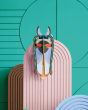 Studio roof slotting card cosmos beetle figure attached to a pink patterned panel in front of a green wall