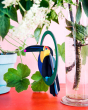 Close up of a Studio Roof eco-friendly cardboard Toucan decoration hanging from a plant branch in a clear beaker