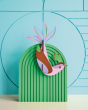 Studio roof eco-friendly maui bird card model attached to a green stand in front of a blue patterned wall