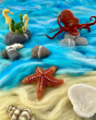 A felted The Makerss Starfish, Seahorses and Octopus in a felted beach scene with blue felt sea, light sand pebbles and shells