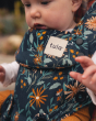 Close up of the Tula Explore Baby Carrier in Lush Field showing the Tula logo
