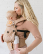 Close up of woman kissing a baby in a Tula explore front facing baby carrier