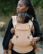 Close up of woman holding a baby in a Tula beige herringbone explore baby carrier