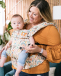 Woman stood wearing a baby on her front in the Tula explore charmed baby carrier