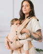 Woman carrying a baby in a Tula explore beige baby carrier