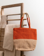 Turtle Bags eco-friendly orange block colour tote bag hanging on a wooden hook in front of a white wall