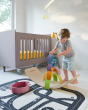 Child balancing wooden coloured arches on top of a Wobbel balance board in a childs bedroom