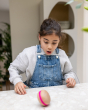 A child looking amazed at the spinning Wobbel Candy Big Macaron, spinning on a marble table 