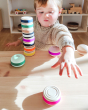 A child playing with Wobbel Candy Cookies and Wobbel Macarons in Malibu, on a wooden table in a playroom 