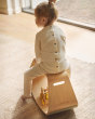 Close up of a young child sat on a plastic-free Wobbel balance box on a grey carpet
