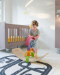 Child stacking multicoloured wooden arches on top of a Wobbel balance board in a childs bedroom
