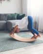 Child playing on a Wobbel Starter Beech Wood wobble board in a white and grey living room