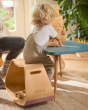 Child sat at a table playing with some wooden toy blocks, sat on a Wobbel Up balance box