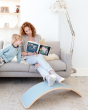 Lady reading child a book using the Wobbel XL Beech Wood balance board as a foot rest in a living room