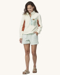 Patagonia Women's Microdini 1/2 Zip Fleece Pullover - Birch White with a light blue pocket and zips, a brown Patagonia logo on the pocket, and brown fleece material on the inside of the arms, showing the fit of the fleece from the front