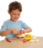 Child building a sandwich with the Erzi Cutting Sandwich Wooden Play Food Set at a table.