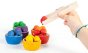 Grapat Wooden Toy Bowls & Acorns Set - 6 rainbow coloured small wooden bowls each with 6 coloured acorns and a set of wooden tweezers. White background with child holding tweezers.