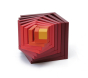 Naef's Cella cube in red twisted to make a swirling pattern from the different cube pieces. Cube is placed on a white background.