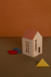 Terra babai medium dollhouse toy on a brown surface in front of an orange wall