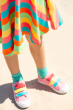 Close up of the bottom of the Frugi Rainbow Stripe Spring Skater dress being worn by child