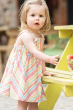 Young child wearing the Frugi Stripe dress Beach Party Dress outdoors