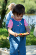 Child wearing the Frugi Chambray Bumblebee yellow Daisies Gracie Reversible Dungaree on the chambray denim side 