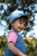 Child wearing the Frugi Chambray Bumblebee Yellow Daisies Helen Reversible Hat on the chambray denim side