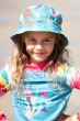 a child wearing blue swim hat with the colourful seashells print from frugi