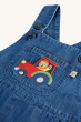 A closer look at the embroidered tractor patch on the front pocket of the Frugi Organic Carnkie Chambray Denim Dungarees - Tractor. Inside the tractor is a lion waving, on a cream background.