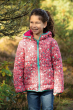Girl stood in some trees wearing the Frugi eco-friendly mountain flora reversible toasty trail jacket
