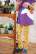 Close up of a child stood next to a trolley of flowers wearing a Frugi unicorn t-shirt and some floral print leona leggings