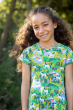 Child smiling wearing the Frugi Hedgerow print Spring Skater Dress showing the top of the dress