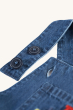 A closer look at the button fasteners on the shoulder straps, of the Frugi Organic Carnkie Chambray Denim Dungarees - Tractor, on a cream background