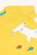 A closer view of the Frugi Children's Organic Cotton Jaime Applique T-Shirt - Shark. The front of the short-sleeved t-shirt showing shoulder pop fasteners, a fun Hammerhead Shark applique design and colourful fish on a sunny yellow fabric. T-shirt is on a
